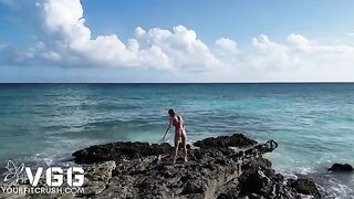 A sexy girl is naked on the beach and caressing her body