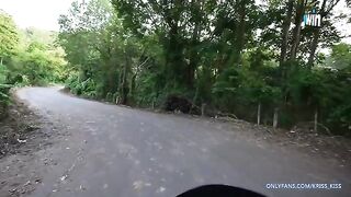 A girl is having her first ride on a motorbike in the jungle