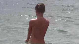 A group of nudists enjoy each other's company on the beach