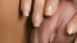 Girl caresses her hairy pussy with a large clitoris, showcasing her unique charm