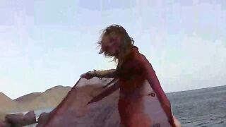 A sexy girl is walking on the naked beach and playing with her boobs