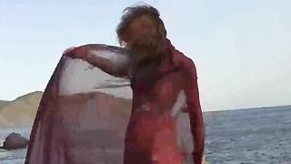 A sexy girl is walking on the naked beach and playing with her boobs