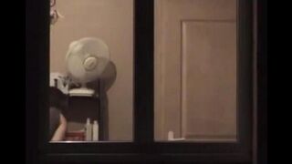 The guy admires himself in the mirror, standing completely naked in front of it