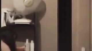 The guy admires himself in the mirror, standing completely naked in front of it