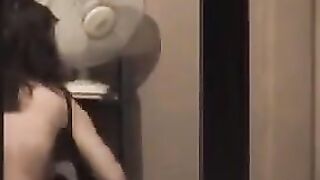 The guy admires himself in the mirror, standing completely naked in front of it