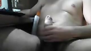 A guy masturbates his cock with his hands while sitting in front of the computer