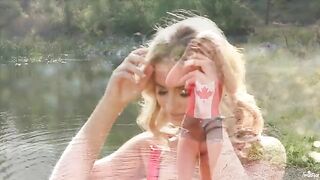 A blonde girl caresses herself tenderly right in the lake