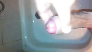 The kid masturbates his cock with his hand in the shower