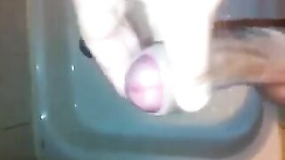 The kid masturbates his cock with his hand in the shower