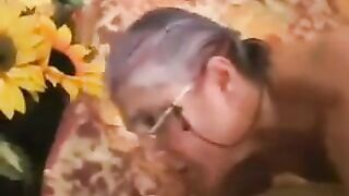 A mature gray-haired woman in black stockings gets fucked by a man