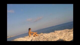 The girl has no shame and sunbathes completely naked on the beach