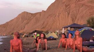 A group of nudists play volleyball on the naked beach