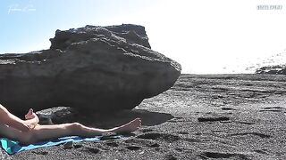 A girl removes her swimsuit and rubs herself on the beach