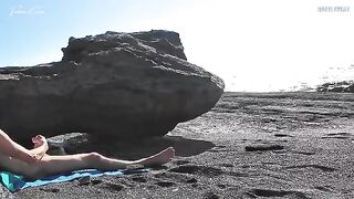 A girl removes her swimsuit and rubs herself on the beach