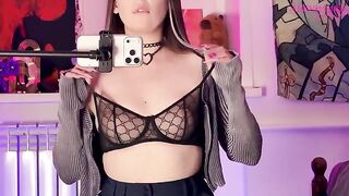 A girl with long legs caressed herself through her clothes in front of the mirror